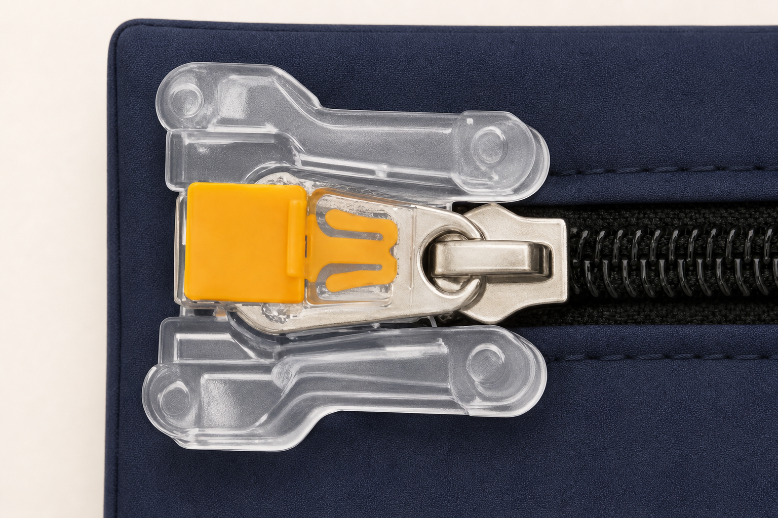 Close-up of the transparent zipper-lock base with the metal zipper pull held beneath an inserted yellow seal.